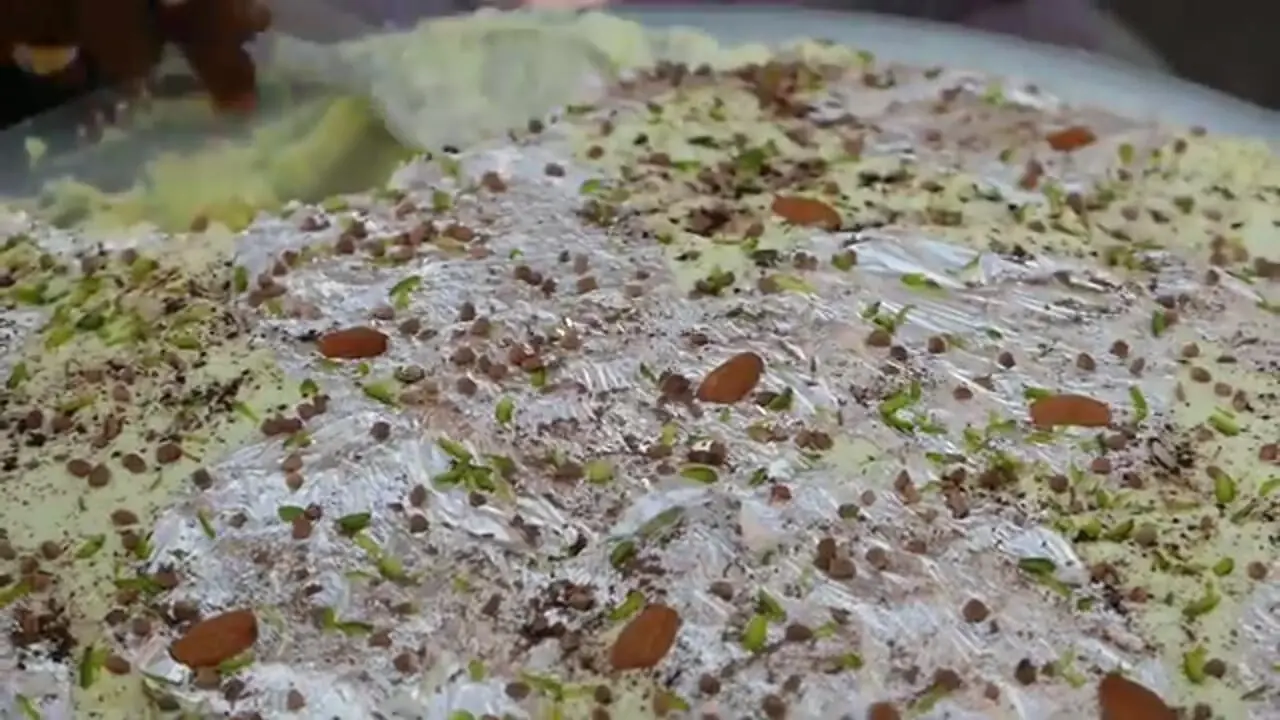 غذای خیابانی در هند؛ تهیه دسر خامه شیر با بادام و پسته در کانپور