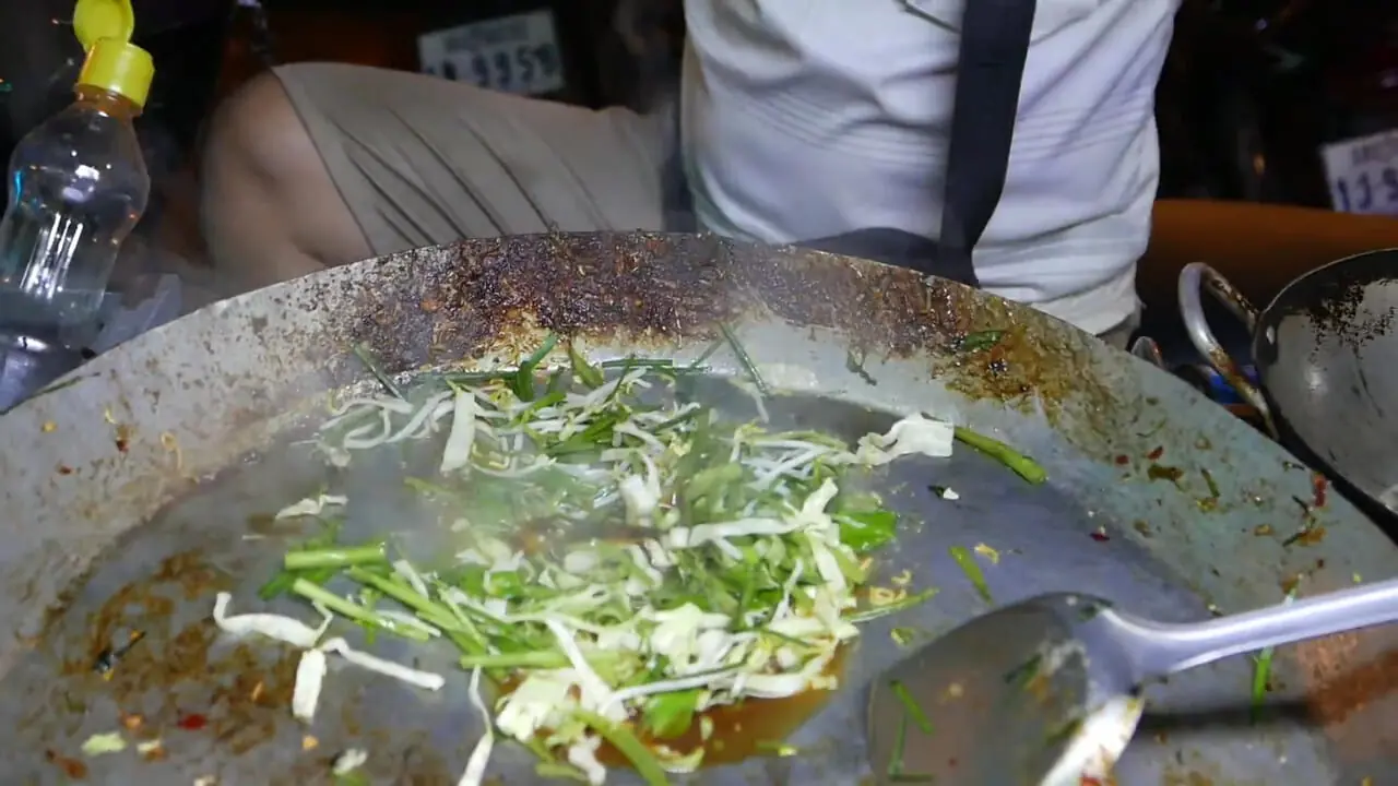 غذای خیابانی در کامبوج؛ تهیه نودل سرخ شده با تخم مرغ و سبزیجات در سیم ریپ