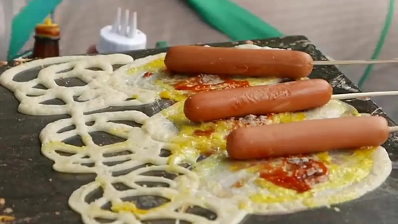 غذای خیابانی در تایلند؛ تهیه ساندویچ با هات داگ، تخم مرغ و پنیر در بانکوک