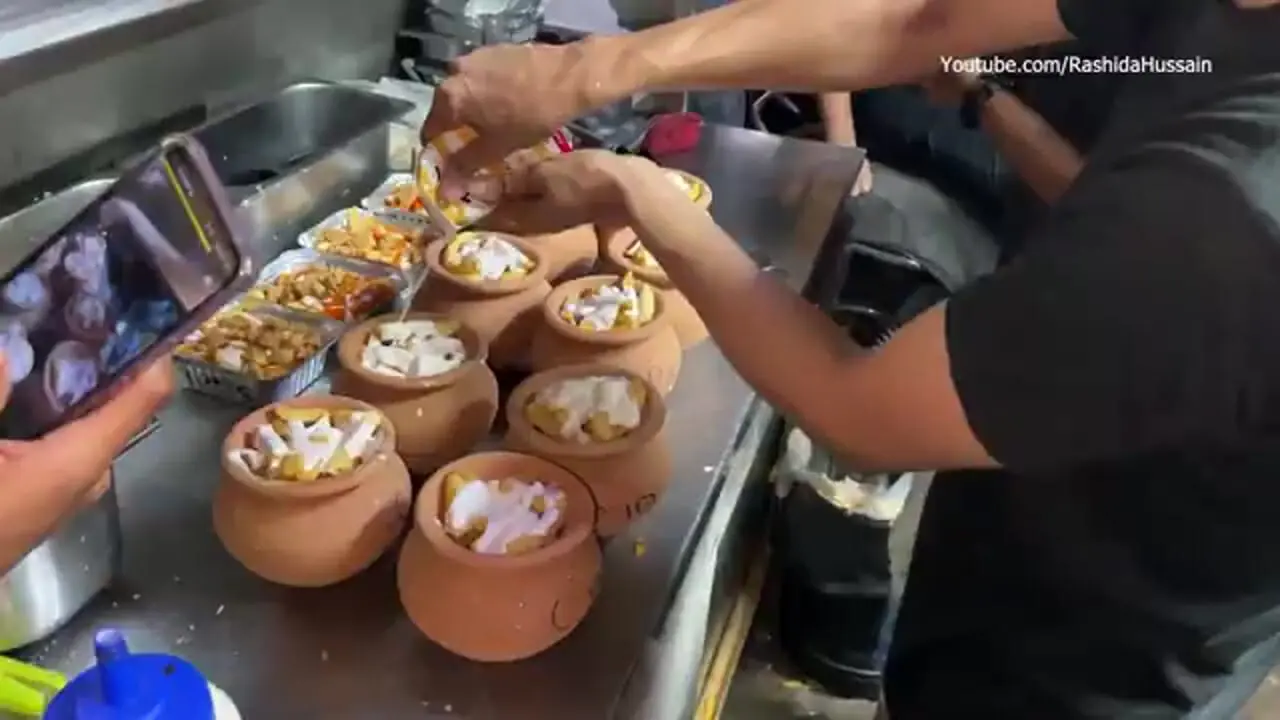 غذای خیابانی در پاکستان؛ پخت یک غذای خاص با سیب زمینی و پنیر خامه ای در کوزه در کراچی