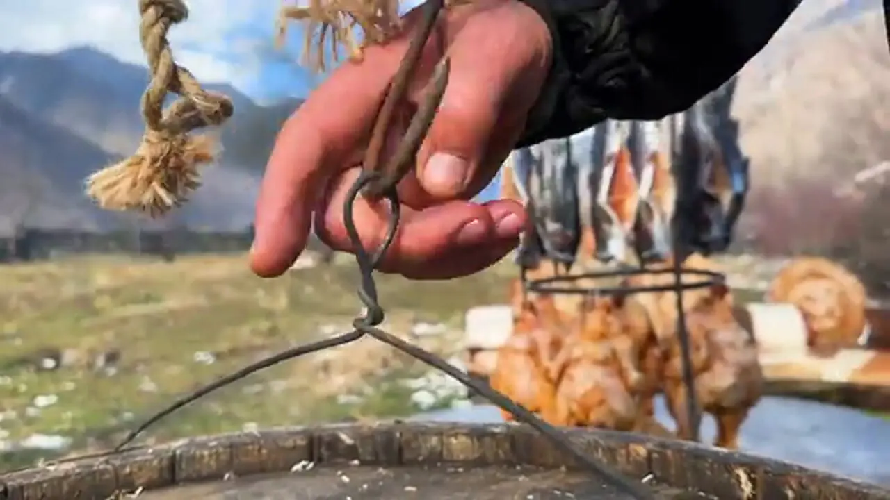 ببینید| غذای روستایی در آذربایجان؛ دودی کردن مرغ و ماهی در بشکه در هوای برفی روستا