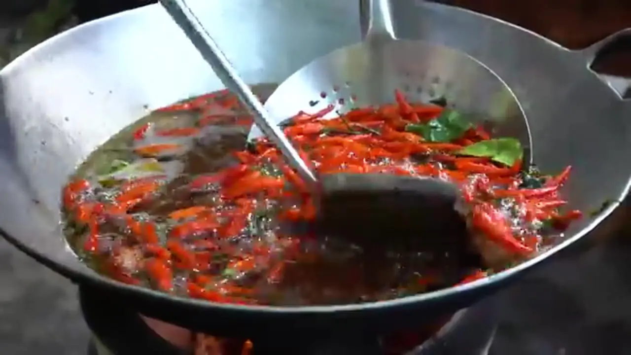 ببینید| غذای روستایی در کامبوج؛ پخت یک غذای سنتی با ماهی بزرگ و فلفل قرمز در تابه