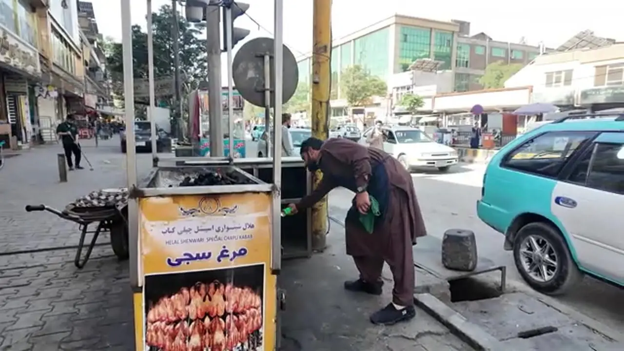 ببینید| غذای خیابانی در افغانستان؛ بریان کردن مرغ کامل روی هیزم در کابل